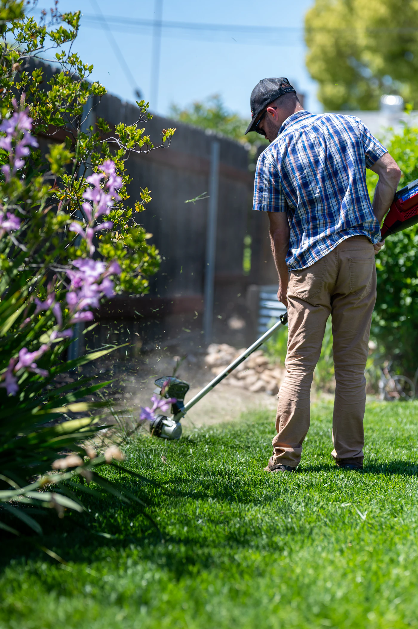 A lawn care technician actively working on a residential property