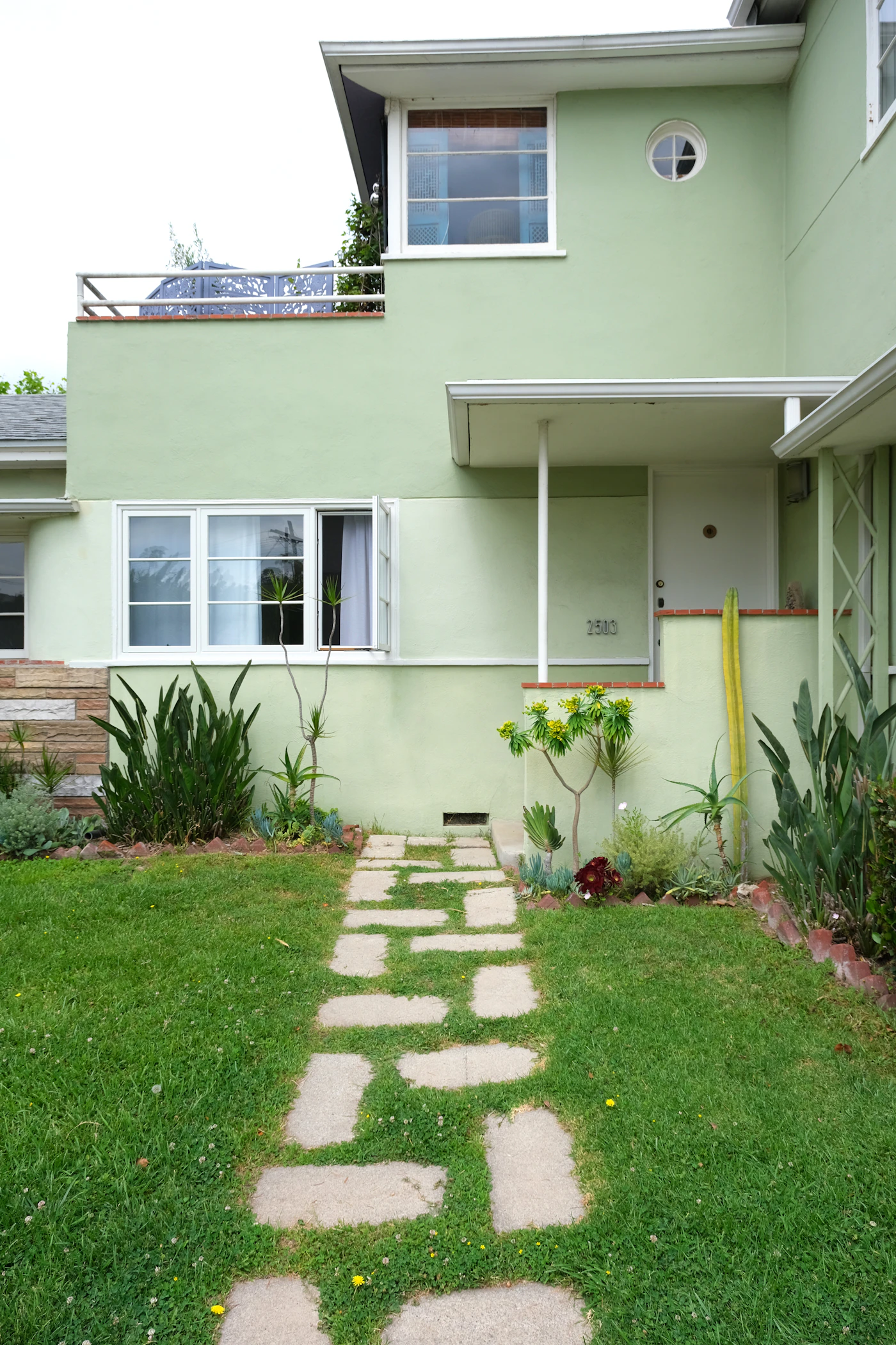 A tidy residential property with a manicured lawn and stone walkway